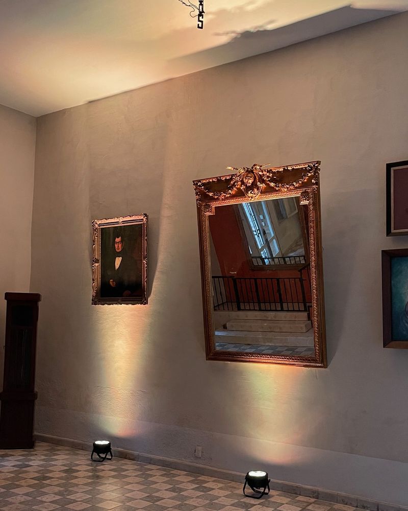 Muro terminado con espejo antiguo e iluminación